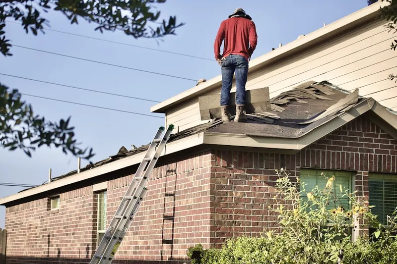 Professional roofer working on a residential roof in Bartlett Park